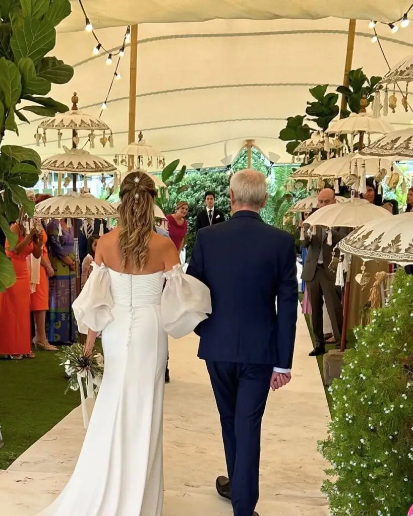 Novia entrando en ceremonia de boda civil en Badajoz bajo carpa con sombrillas decorativas