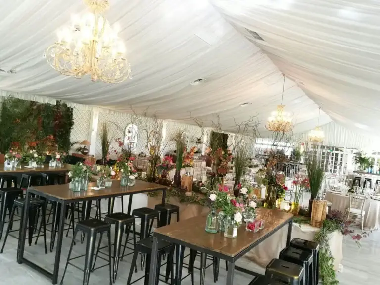 Salón entoldado con techo drapeado en blanco y mesas montadas